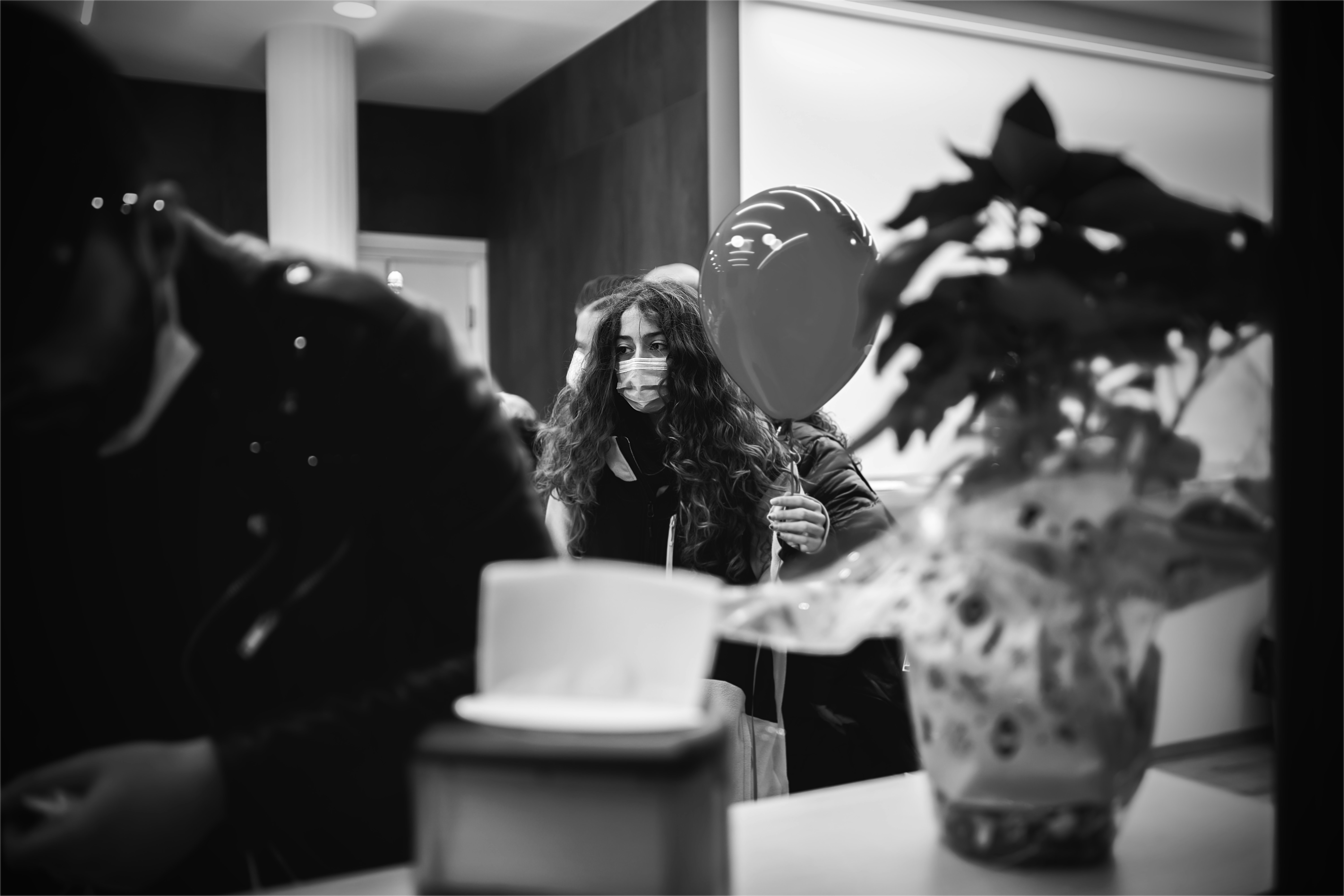 grayscale photo of woman in black jacket sitting on chair